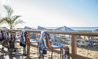 Beach Chairs with Blue and white towels facing the ocean