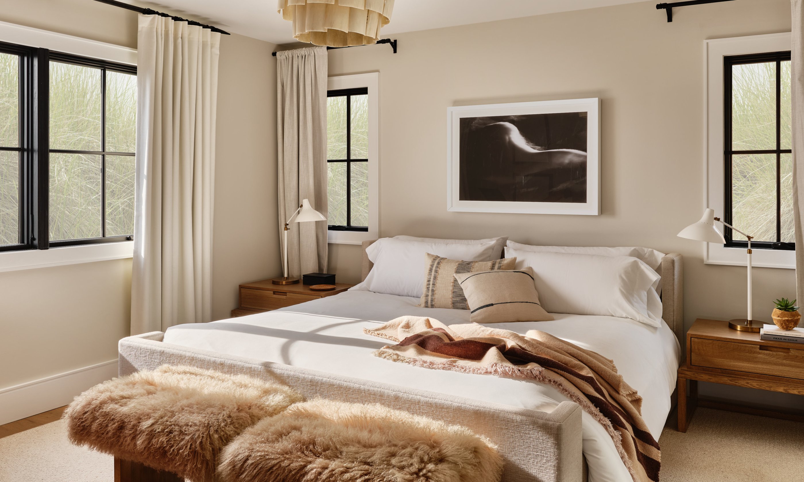 Bedroom with king bed, nightstand, and chandelier.