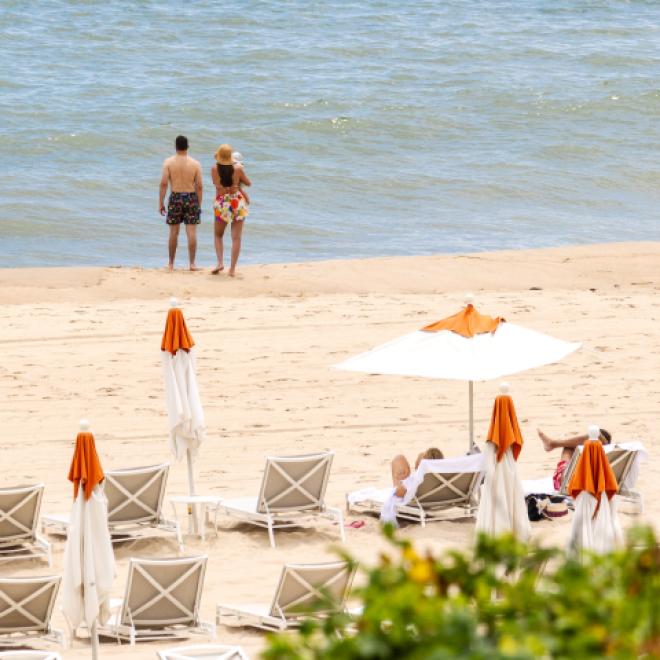 A couple with a small child stand near the water's edge on the private beach at 168极速赛车官方开奖结果记录体彩