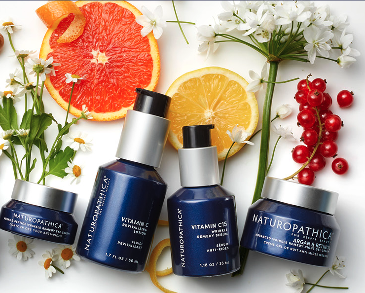 Naturopathica products displayed next to fresh ingredients like oranges.